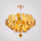A Clérachic agate chandelier in amber and yellow tones on a pale grey backdrop, with a yellow slice at the tip.