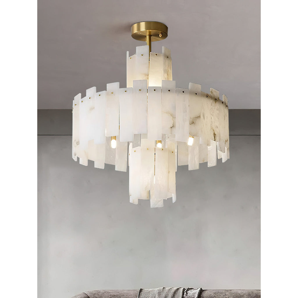 The Clérachic Tiered Alabaster Chandelier lit close to a grey ceiling, its overlapping slabs glowing above a sofa.