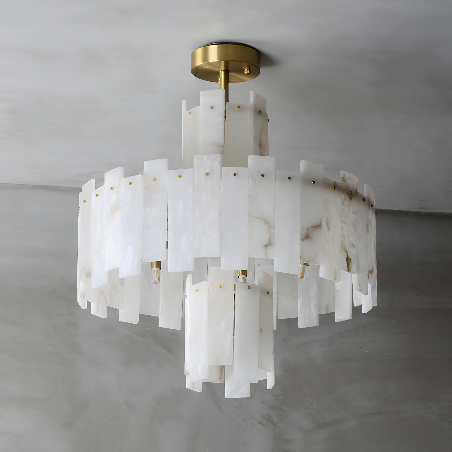 Angled view of the Clérachic Tiered Alabaster Chandelier, brass studs pinning each alabaster slab to the frame.