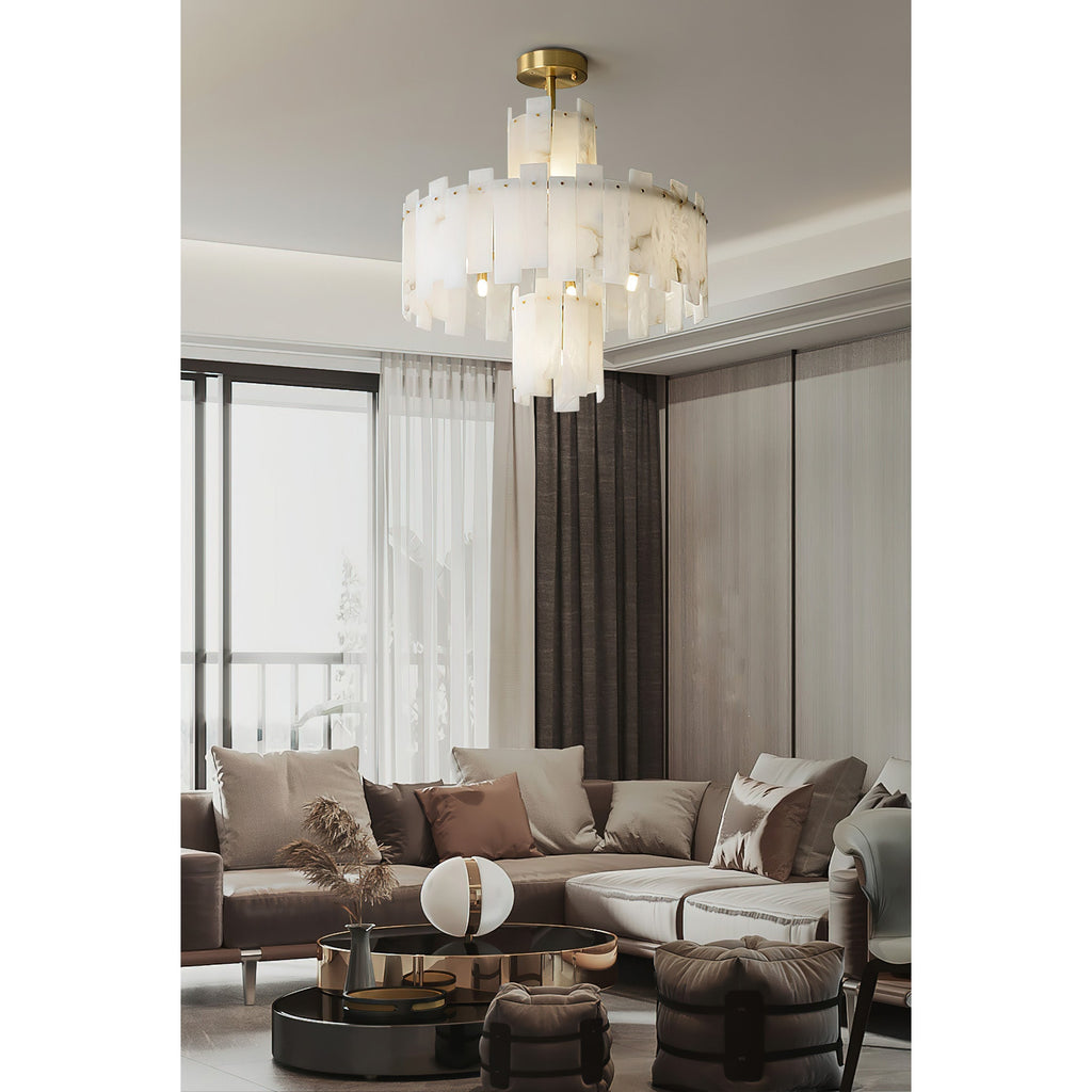 Clérachic Tiered Alabaster Chandelier lighting a large living room with sheer curtains and a pale sectional sofa.