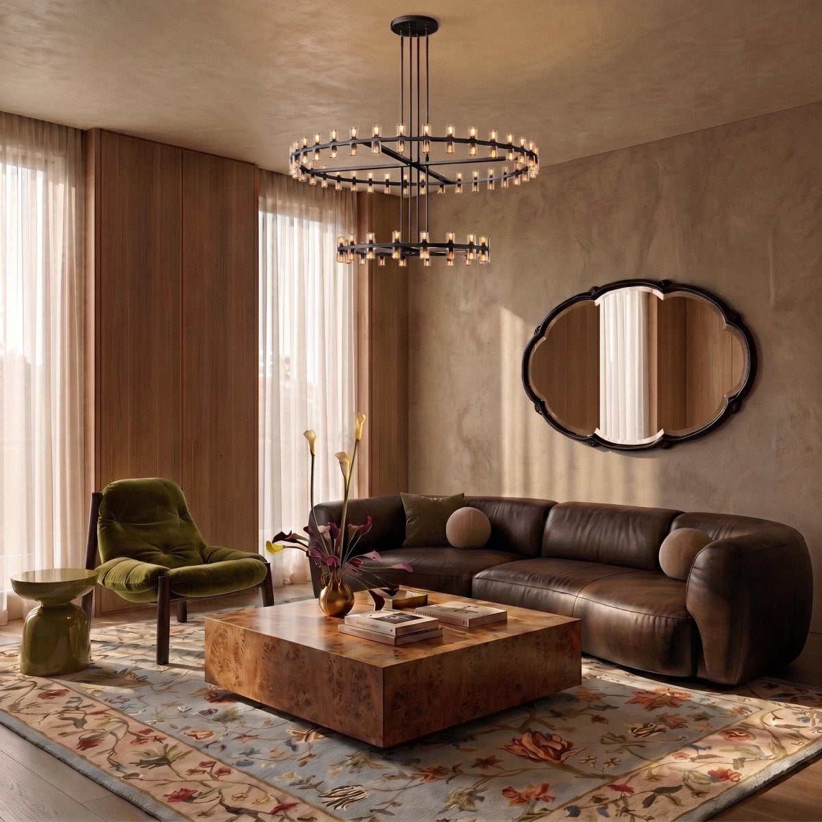 Clérachic matte black tiered chandelier hung over a living room with a brown leather sofa, a burl coffee table and an oval mirror.