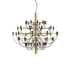 A large Clérachic chandelier with a polished gold stem, many slim arms and looping black cables, on a white backdrop.