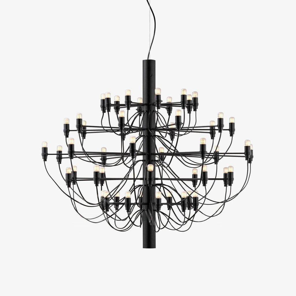 A Clérachic tiered chandelier in matt black, with slim arms and exposed bulbs around a central stem, on a plain white backdrop.