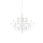 A small Clérachic chandelier in matt white with slim arms and exposed bulbs, almost blending into its white backdrop.
