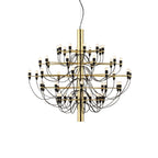 A Clérachic chandelier with a polished gold stem and many curved black cables, on a plain white backdrop.