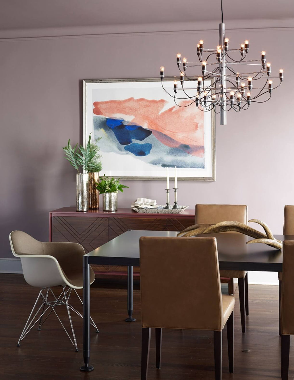 This Clérachic chandelier hangs in a mauve dining room, above a dark table with tan chairs and a framed abstract print.