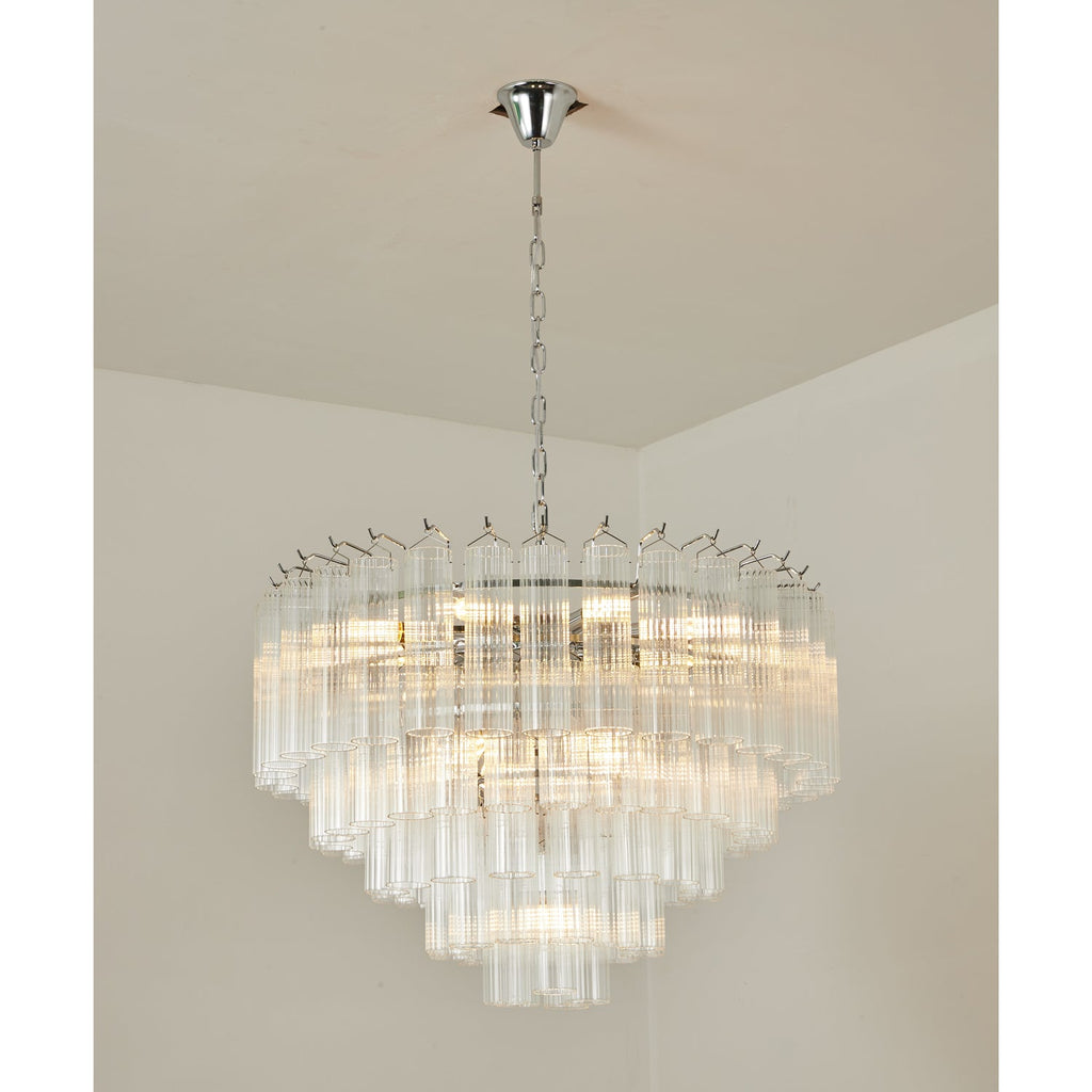 Lit Clérachic chandelier with chrome fittings, its stepped tiers of fluted glass rods shining in a room corner.