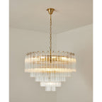 A wide Clérachic chandelier with five stepped tiers of clear glass tubes, lit, hanging from a gold-toned chain.