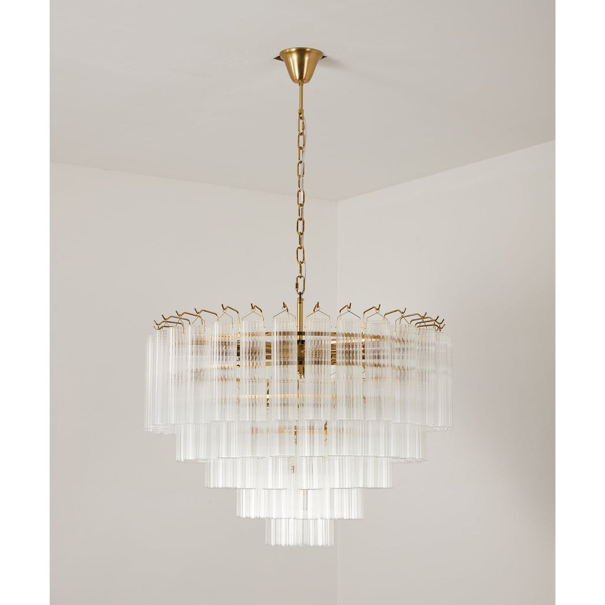 Unlit wide Clérachic chandelier, its five stepped rings of ribbed clear glass showing a gold-toned frame inside.