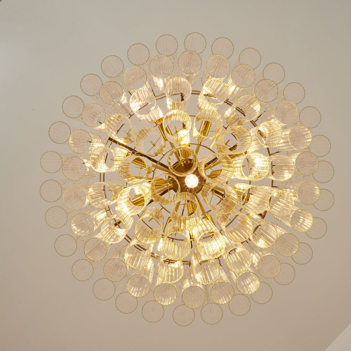 View from below of this Clérachic chandelier, showing the circular glass rod ends fanning out around a gold-toned centre.