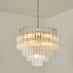Lit Clérachic chandelier with a gold-toned chain and a rounded, tiered cluster of clear fluted glass rods.
