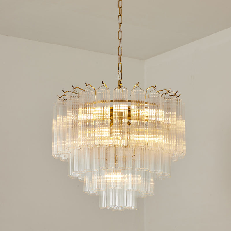 Lit Clérachic chandelier with a gold-toned chain and a rounded, tiered cluster of clear fluted glass rods.