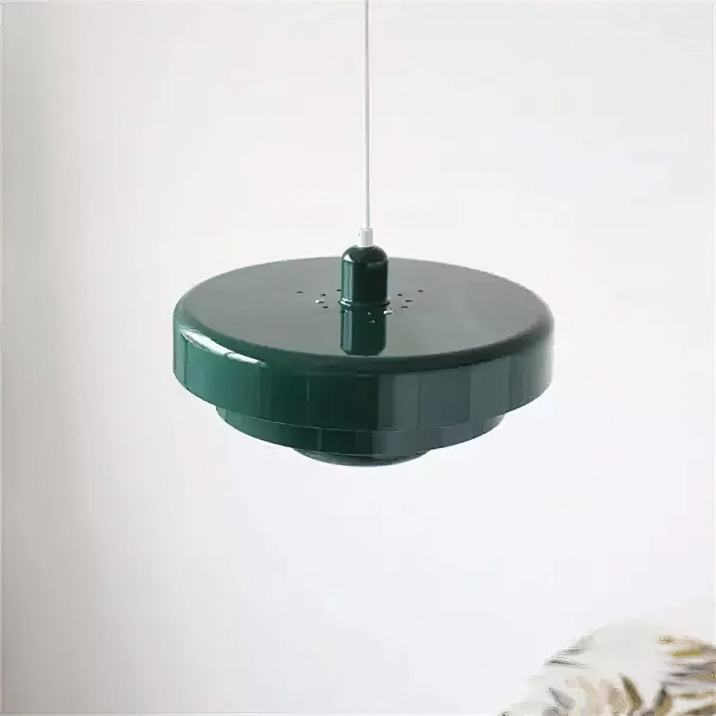 Top-down angle of a dark green Clérachic tiered pendant against a pale wall, showing the smooth top disc and the small vent holes.