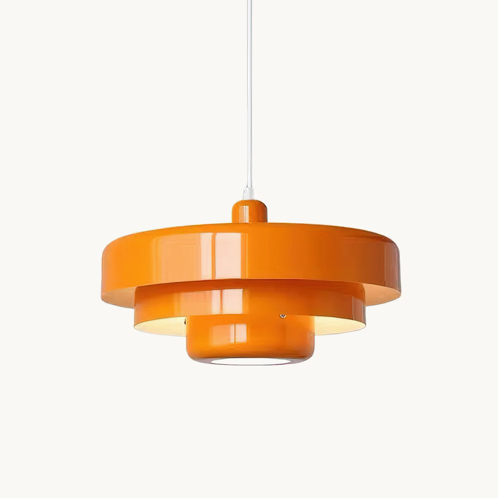 An orange Clérachic tiered pendant on a white cord against a plain white backdrop, with a small screw visible on the lower tier.