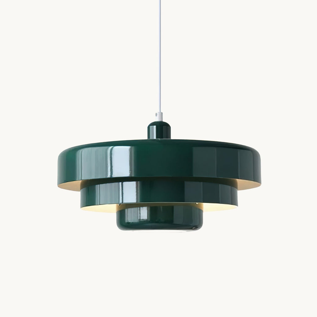 A dark green Clérachic tiered pendant on a white cord against a plain white backdrop, with the glow of the bulb under its tiers.