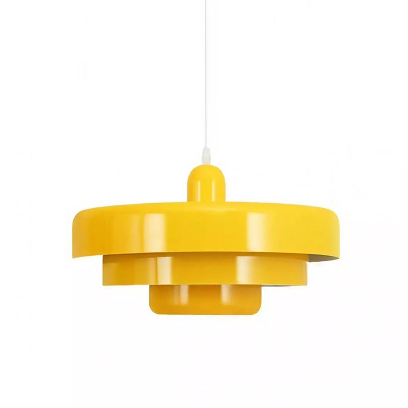 A yellow Clérachic tiered pendant on a white cord against a white backdrop, showing its wide top disc and two smaller tiers below.