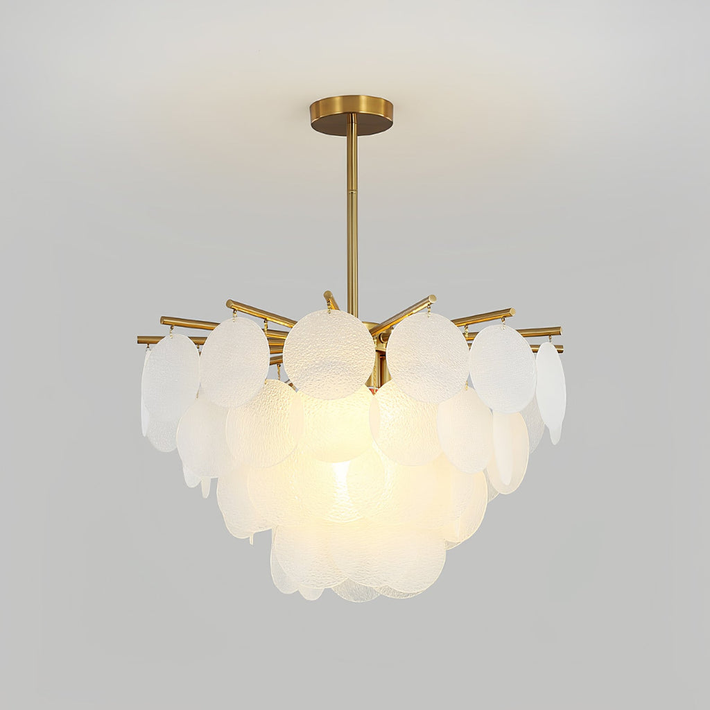 Close, lit view of the layered frosted discs and brass-toned arms of this Clérachic chandelier against a pale grey wall.