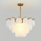 This Clérachic chandelier lit on a grey backdrop, its large frosted discs overlapping in tiers beneath a brass rod.