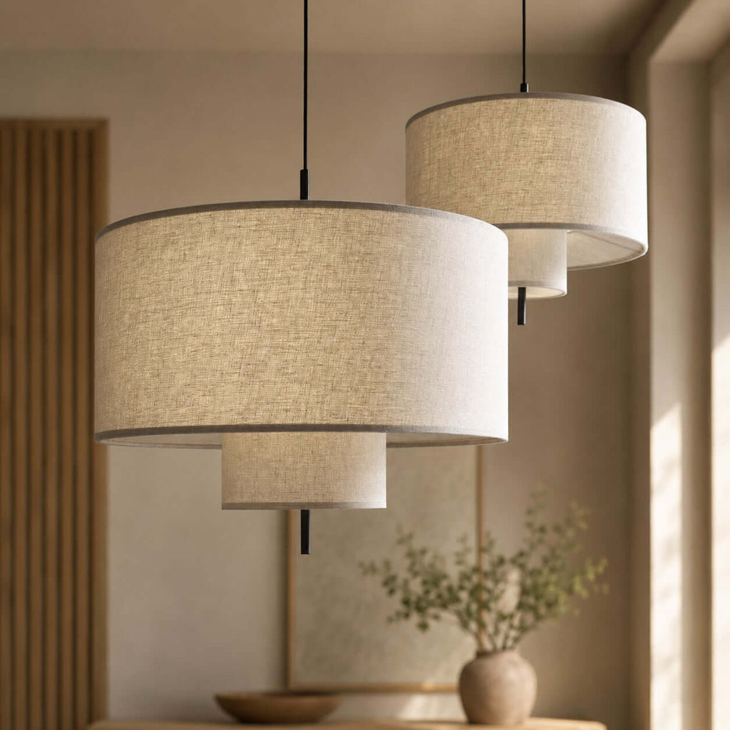 Close view of the woven linen texture and layered tiers on two Clérachic pendants of different sizes, hung side by side.