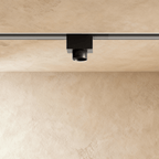 Clérachic magnetic track light in black, the same cylindrical head on its rectangular rail block, unlit and aimed straight down.