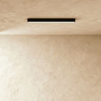 Clérachic linear light head in black, mounted flush to a lime-plastered ceiling with its lit line washing the wall below.