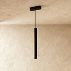Clérachic cylindrical pendant head in black, hanging on a fine cord from a small rectangular ceiling mount.