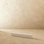 Clérachic power supply in white, the same slim block casting a soft shadow across a plaster floor.