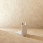 Clérachic track connector in white, the upright right-angle piece seen against a bare plastered wall.