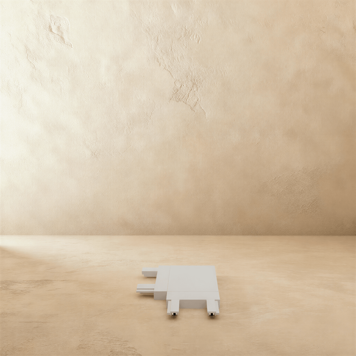 Clérachic track connector in white, the flat corner piece photographed from above on a plaster floor.