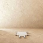 Clérachic track connector in white, its three-way body shown on a bare plaster floor.