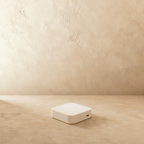Clérachic Zigbee gateway in white, the same compact box seen against a bare plastered wall.
