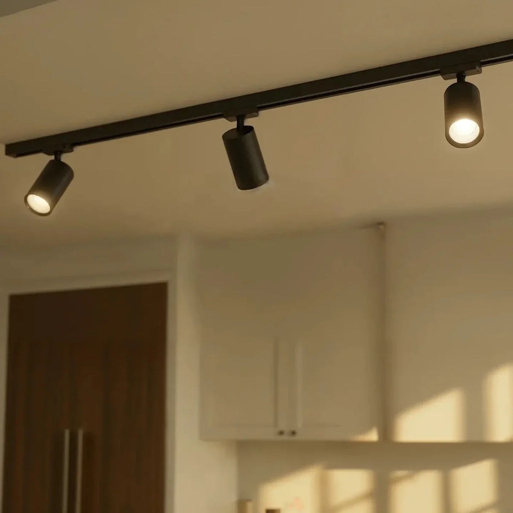 Clérachic spotlight heads in black, three along one rail above a kitchen with the outer two lit and the middle one dark.