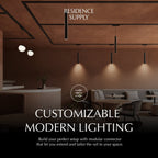 Clérachic track system in black, a rail frame across a café ceiling with slim cylinder pendants dropping over the banquette.