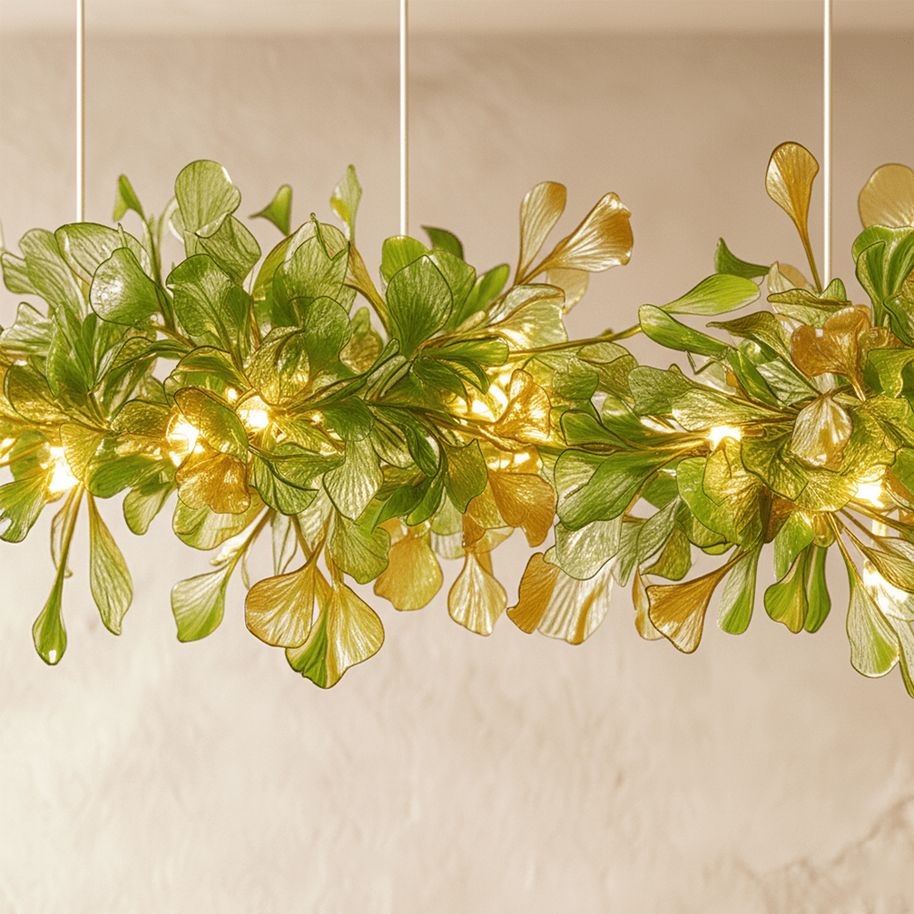 A close detail of the Clérachic chandelier's green glass leaves, lit from within along a brass branch.
