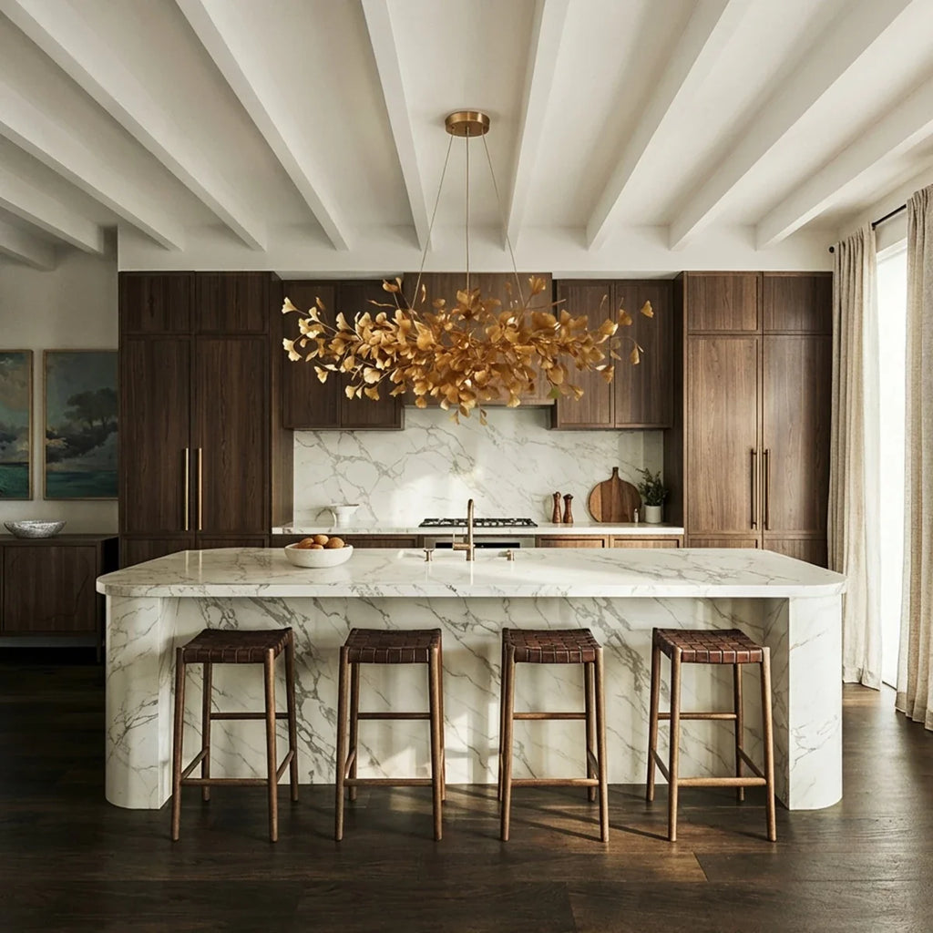 Clérachic's chandelier in its round form, amber glass leaves glowing above a marble kitchen island.