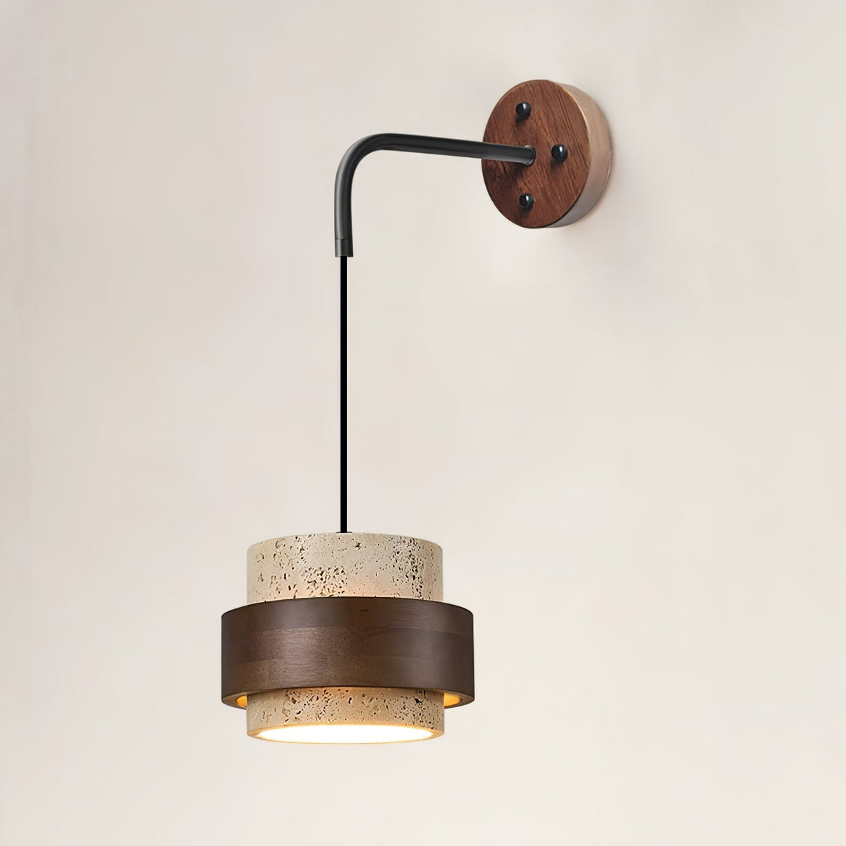 Front view of this Clérachic wall light, its black arm dropping from a walnut wall plate to a lit travertine and dark walnut shade.