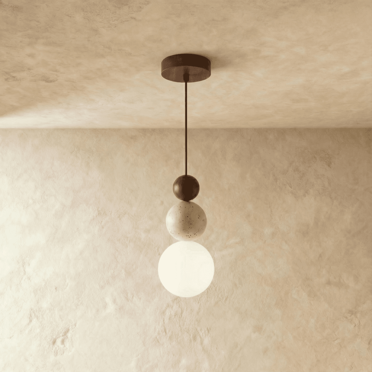 Clérachic stacked pendant with a dark walnut bead, travertine bead and white glass globe on a cord, against a limewashed wall.
