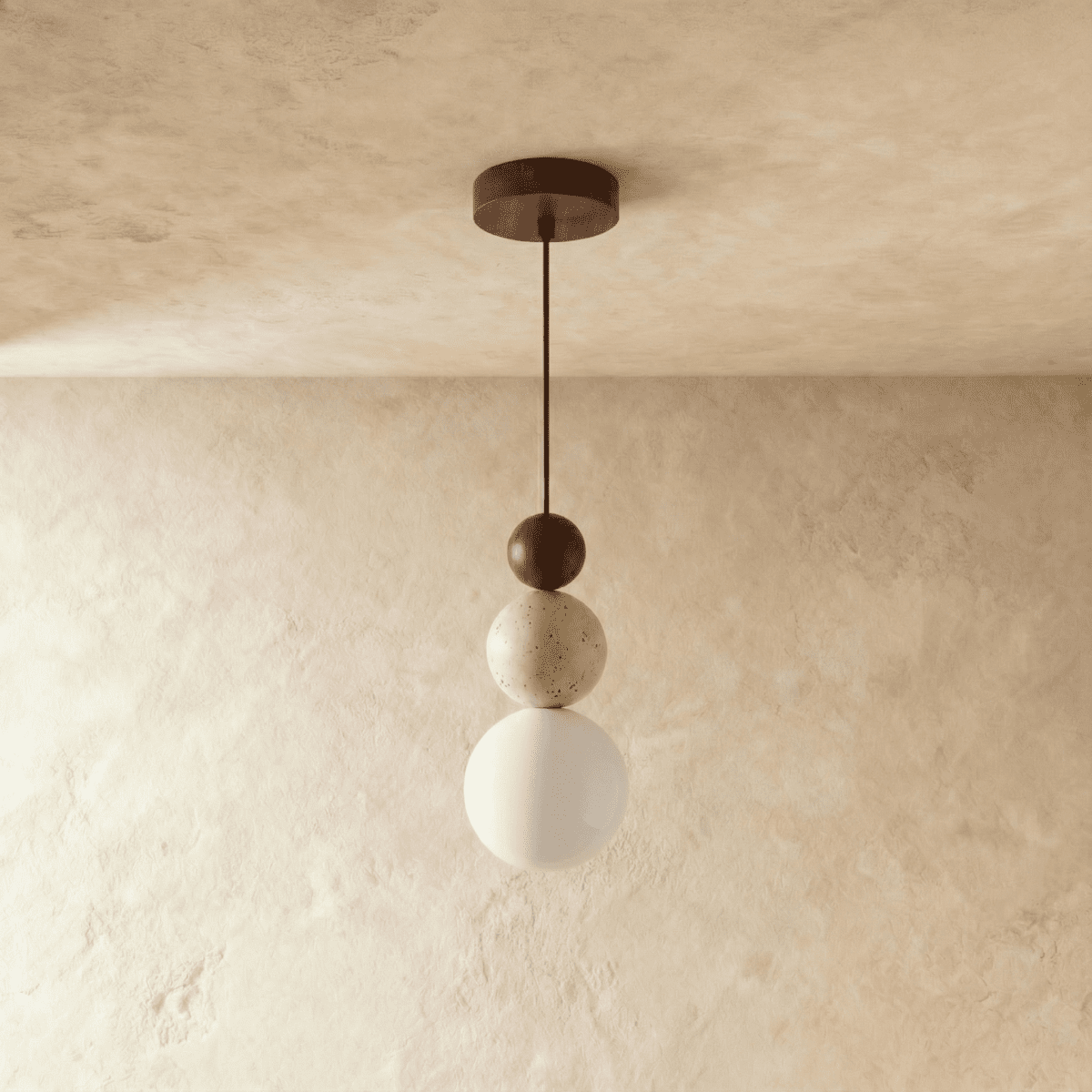 Clérachic walnut-toned stacked pendant with a travertine bead and a white glass globe, shown unlit against soft plaster.