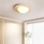 Lit glass dome inside a stone-look rim, this Clérachic ceiling light sits in a bright room beside sheer curtains and a slim potted branch.