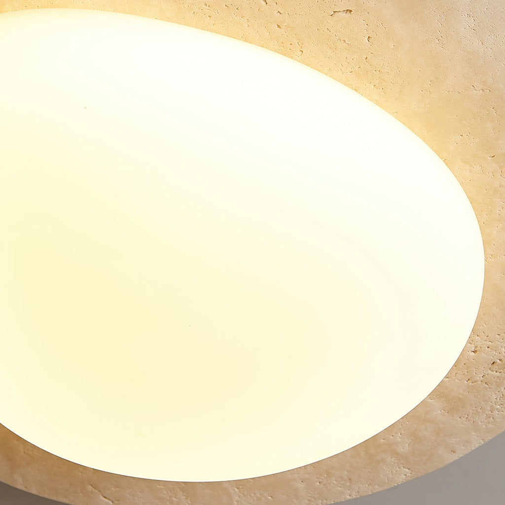 Close view of the smooth, evenly glowing white glass shade on this Clérachic ceiling light, with the stone rim at the edge.