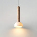 Light pools downward from the white dome of this Clérachic pendant light, hung against a plain pale wall.