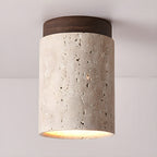 Clérachic ceiling light with a walnut cap, the pale travertine pitted with natural holes and glowing at the lower edge.