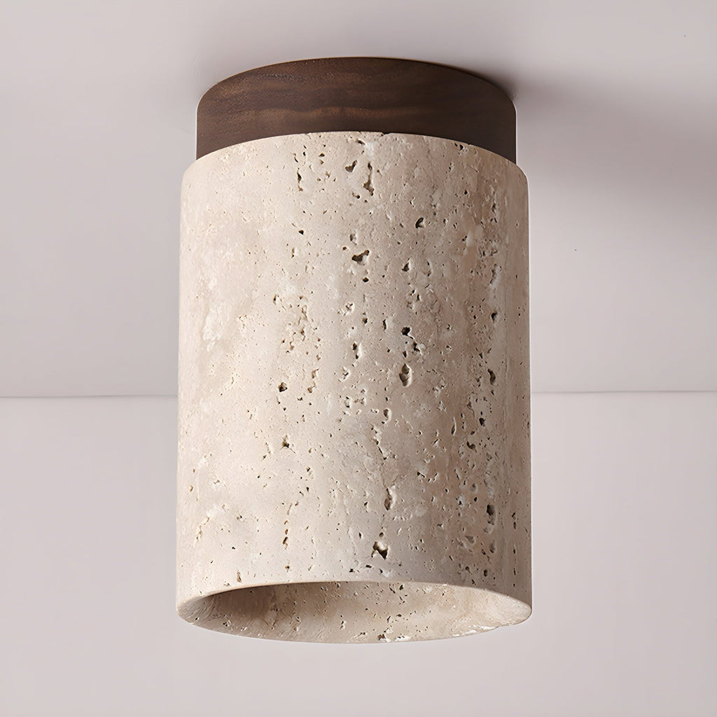 Walnut-capped Clérachic ceiling light viewed from below, with the thick stone rim and natural pores of the travertine visible.