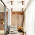 Clérachic travertine ceiling lights in a group of four above a lounge with a low daybed, wood slats and a floor-length curtain.