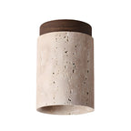 Clérachic ceiling light with a walnut cap on white, the cream travertine speckled with natural holes.