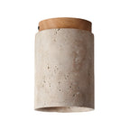 Clérachic ceiling light with a wood-colour cap on white, showing the textured cream travertine of the cylinder.