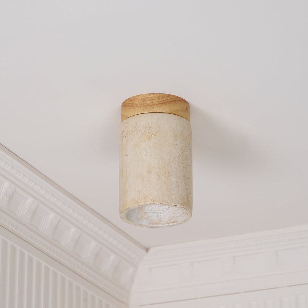 Clérachic ceiling light with a wood-colour cap seen from below at an angle, with white moulding behind it.