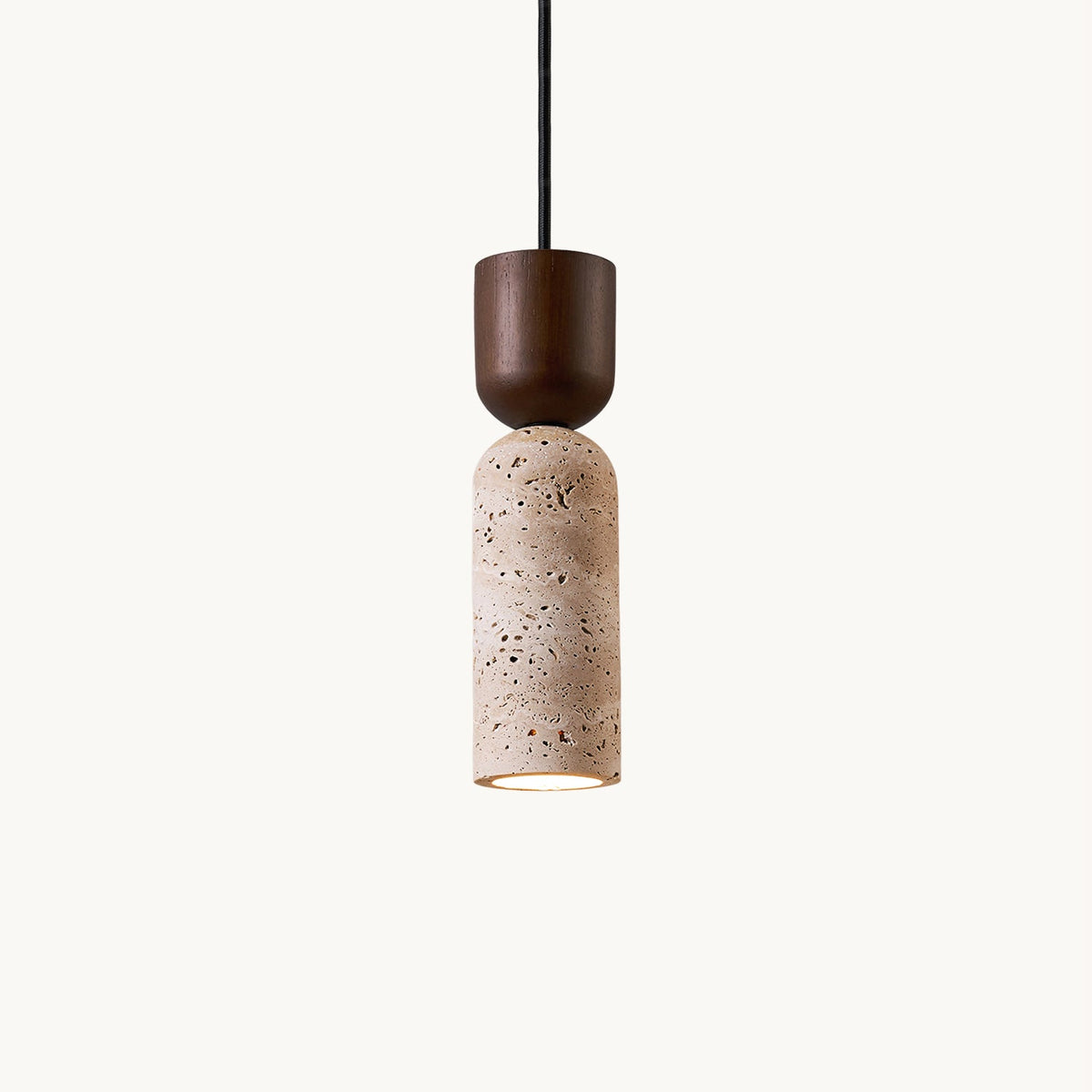 Clérachic travertine pendant on a plain off-white backdrop, a walnut-coloured cap above a pitted beige stone cylinder, lit at the base.