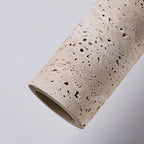 Close view of the pitted travertine surface and open end of this Clérachic pendant cylinder.
