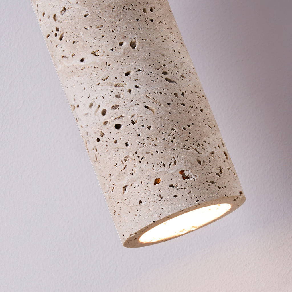 Close view of the lit end of this Clérachic travertine pendant, with the porous stone texture visible around the glowing opening.